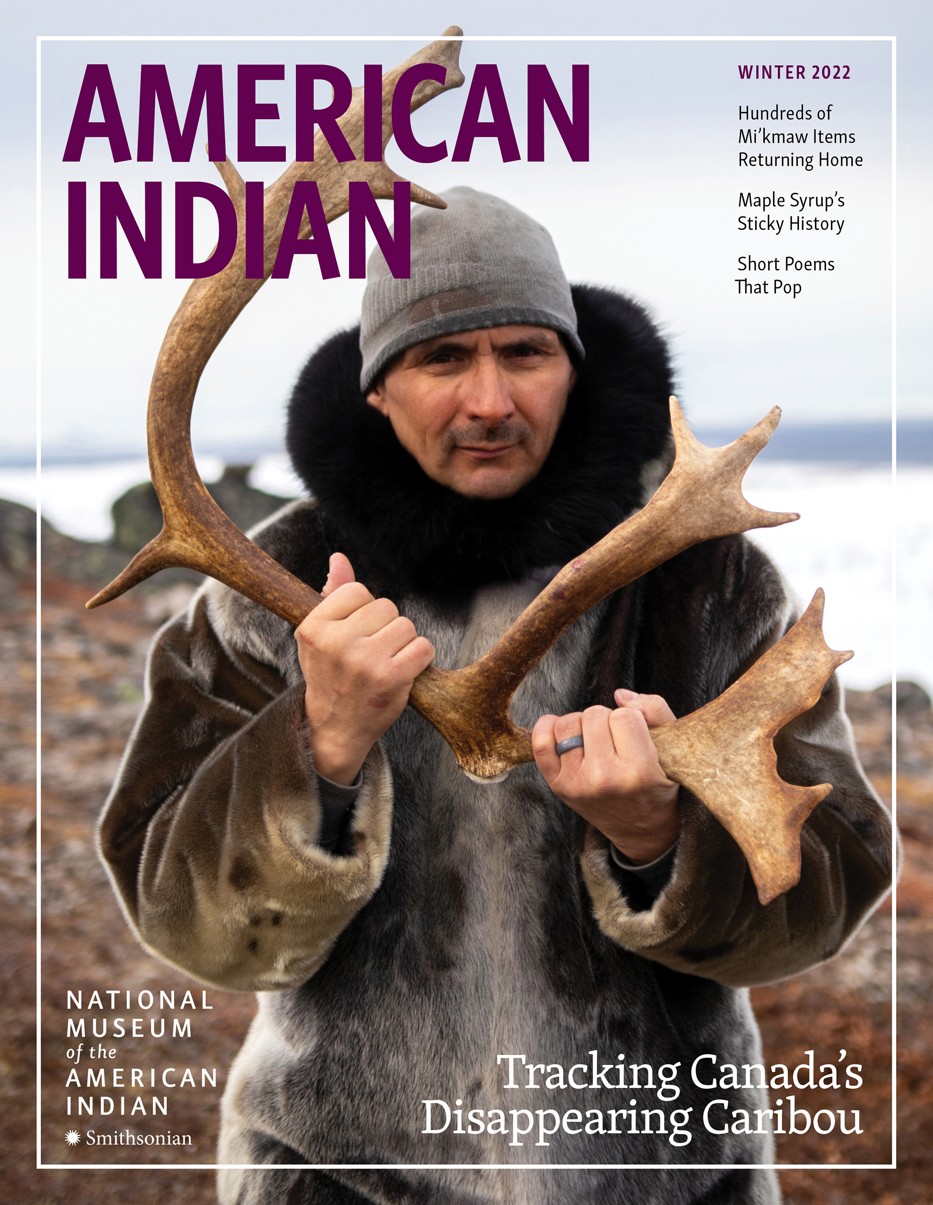 Portrait of warmly-dressed man holding caribou antler.