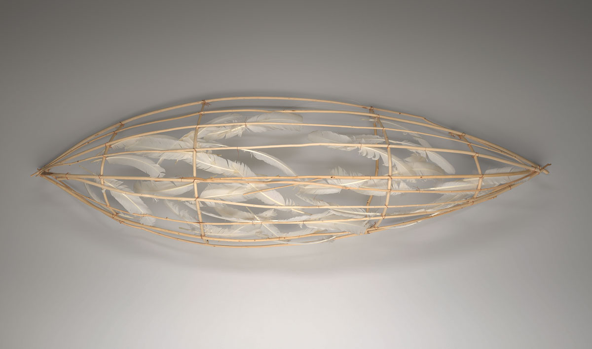 Features rest delicately against the wooden scaffolding of a canoe