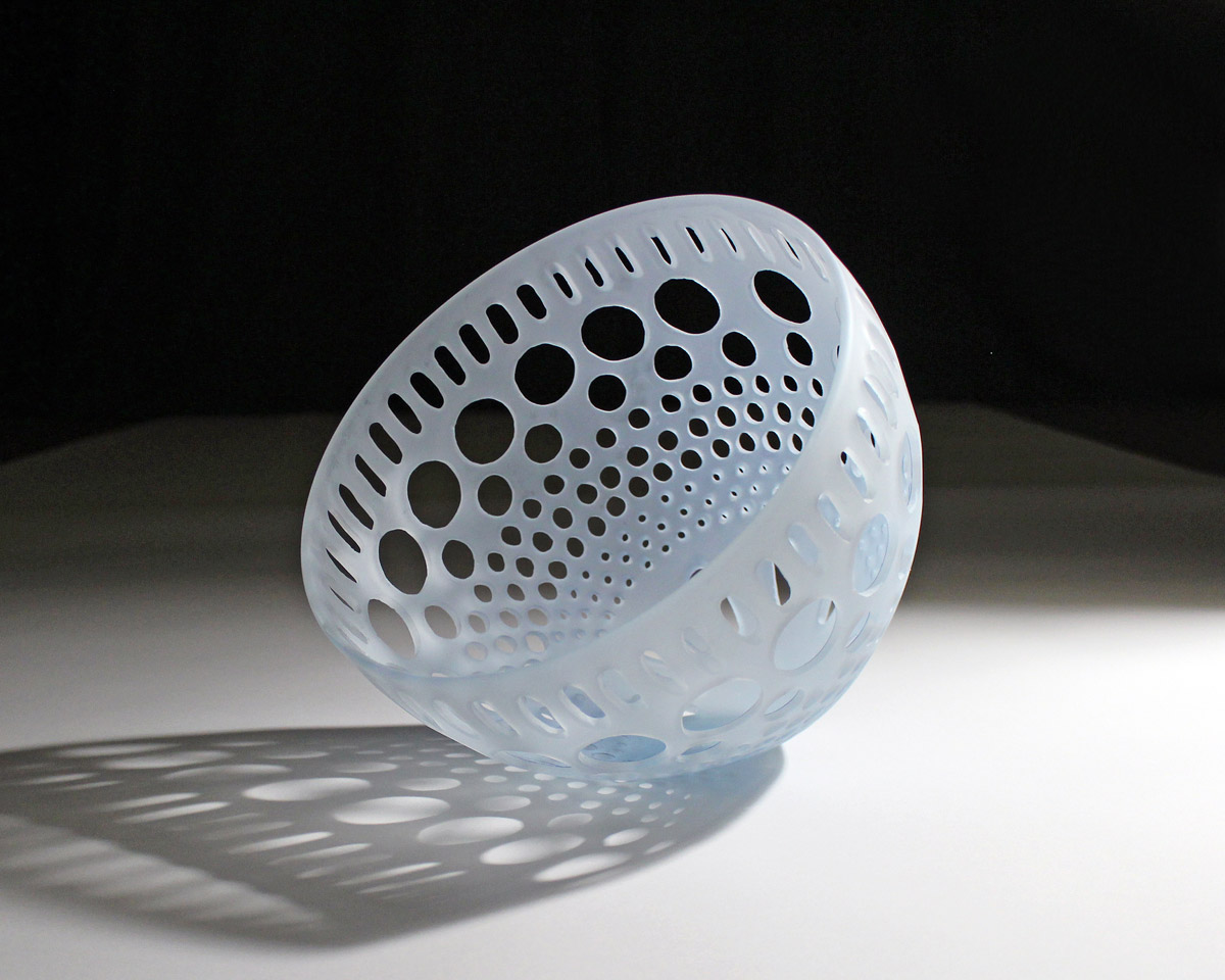 Opague blue-ish white glass sculpture with intricate cut pattern.