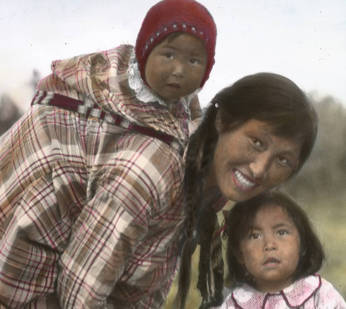 A colorized image of a mother posing with her young children.