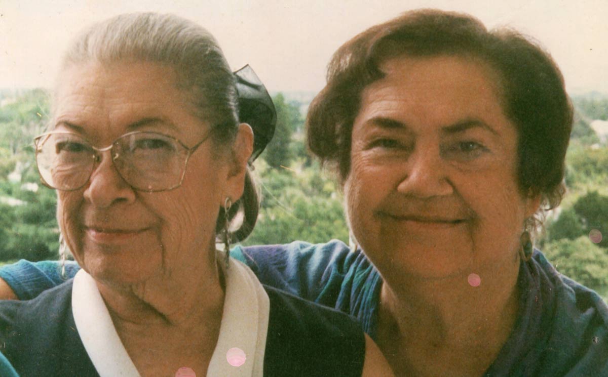 Two women smile together.
