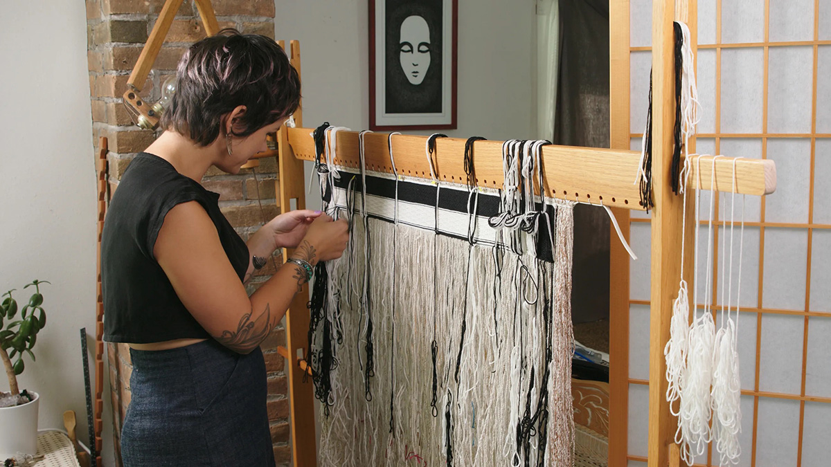 Ursala Hudson works on weaving at a loom