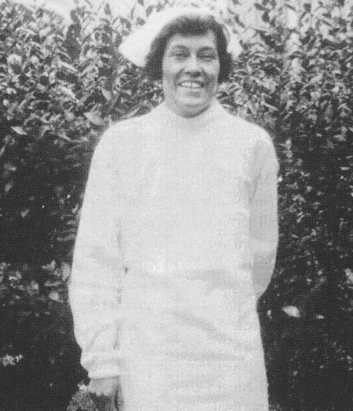 Lula Leta Owl Gloyne wears a nurse's uniform and smiles to the camera.