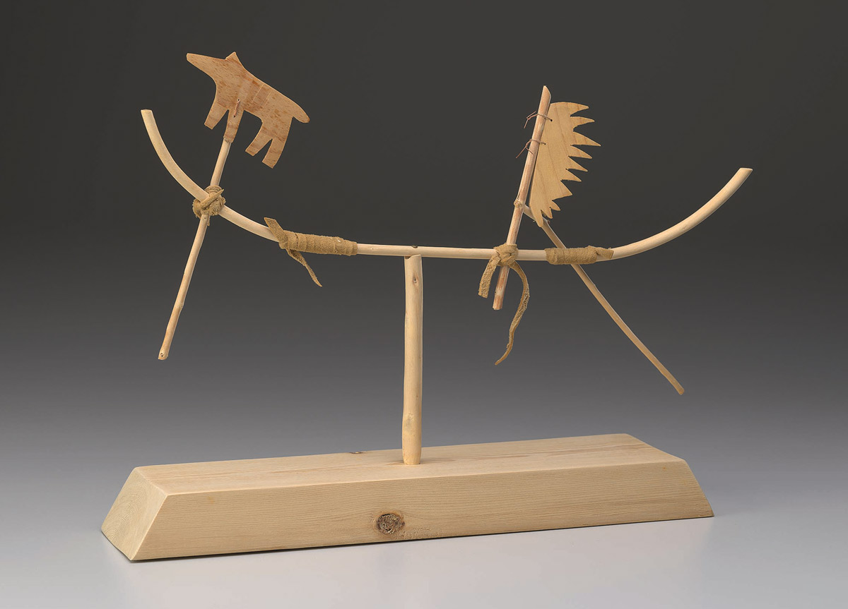 A human and dog silhouette sit atop a curved piece of wood.