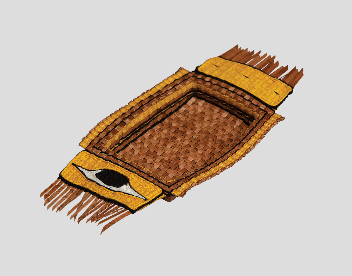 A woven artwork featuring yellow and black designs and cedar bark