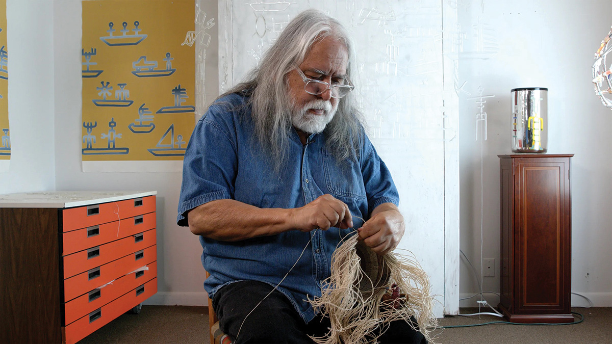Joe Feddersen in his studio, holding textiles