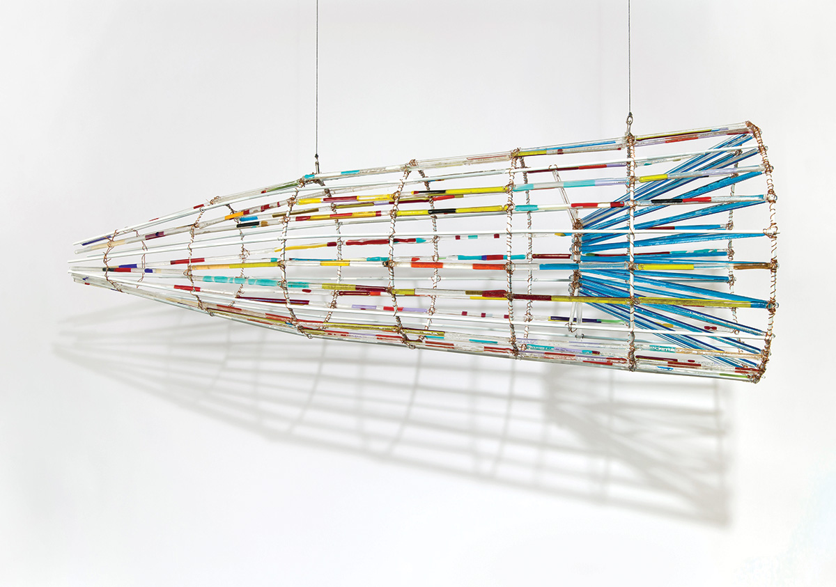 A colorful glass and metal artwork in the shape of a fish trap