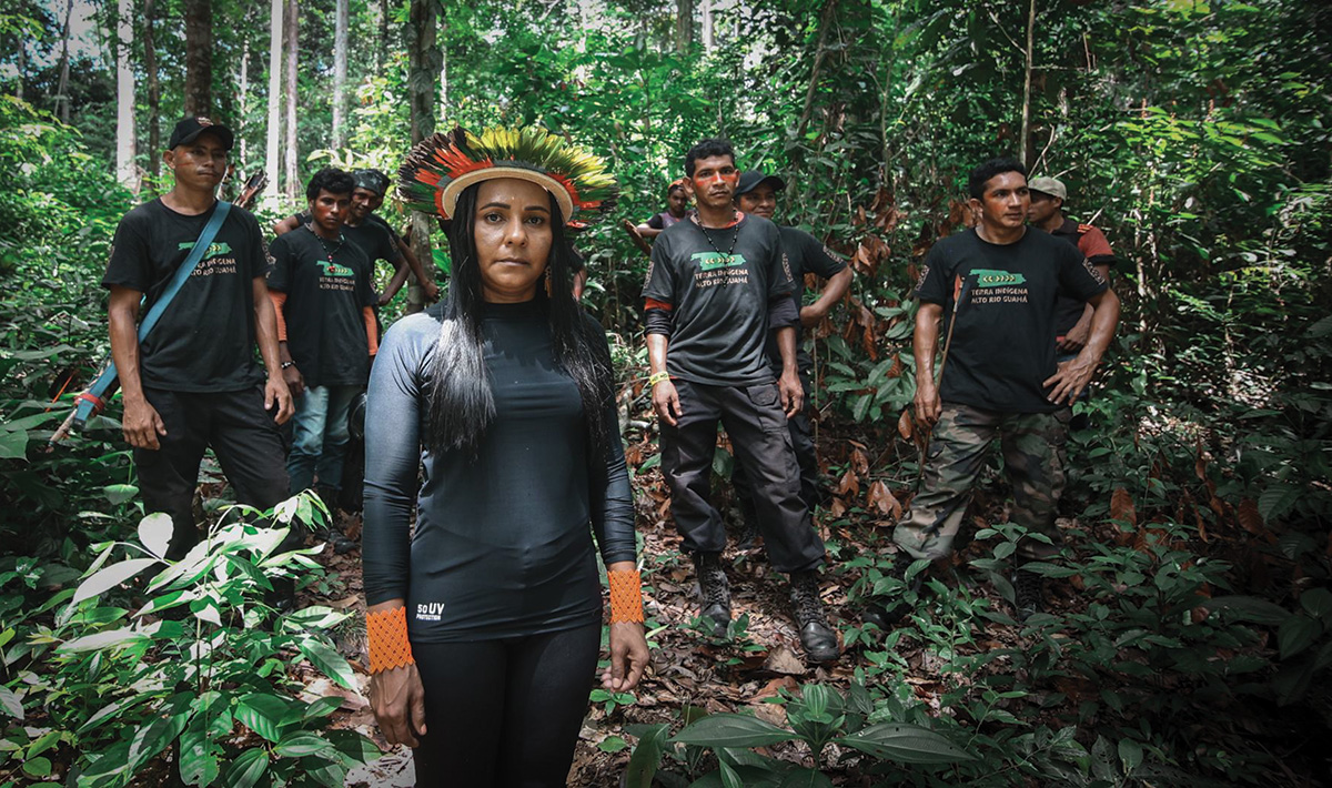 A group of warriors dressed in black stand in a forest