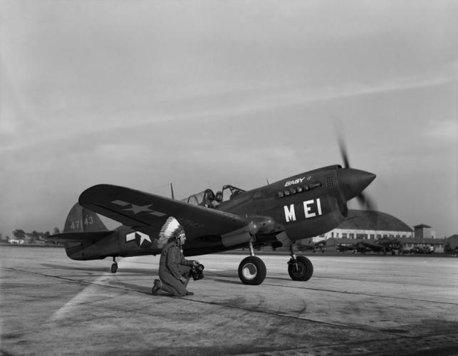 Horace kneels in front of a P-40 Warhawk at MacDill Field. Tampa, Fla., ca. 1944