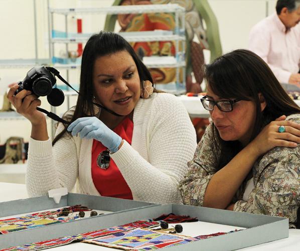 two women photographing and discussing cultural artifacts