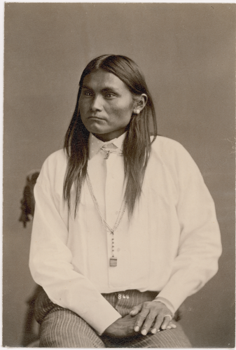 Studio seated portrait of Western Apache man Skellegunney