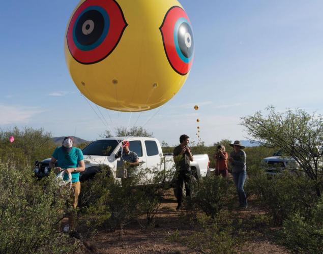 Postcommodity supporters installing one of the scare-eye balloons