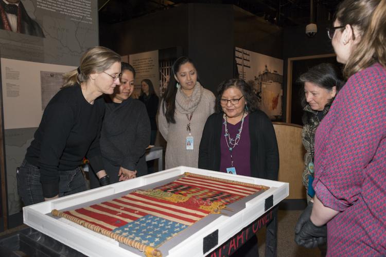 Museum staff inspecting weaving