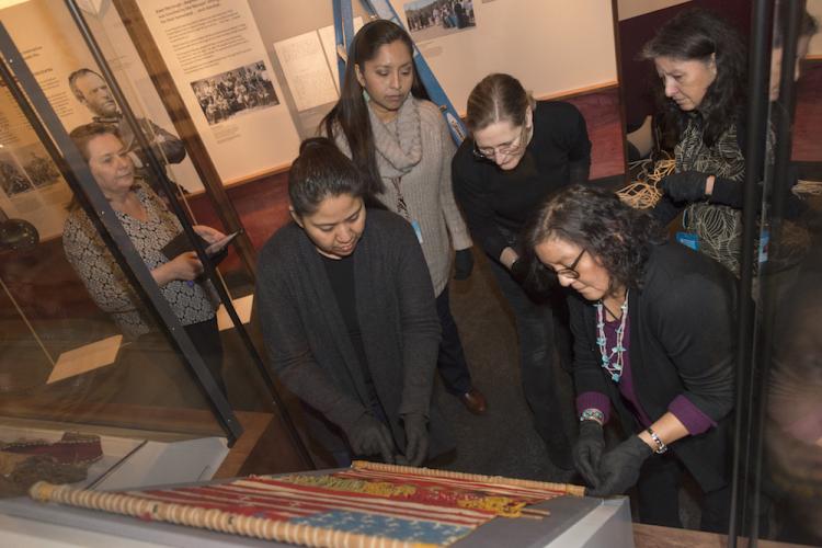 Museum staff inspecting weaving