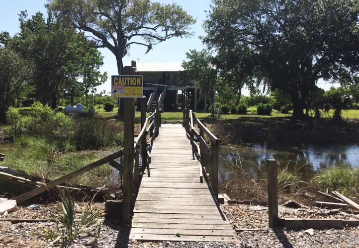 House with bridge and caution sign
