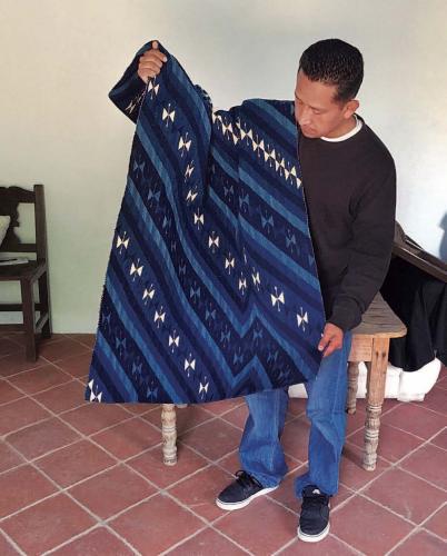 Gutierrez displays a newly made tapestry from the studio.