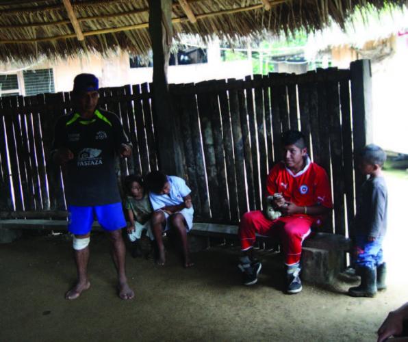 The village chief jokes with tourists in Spanish before the English language tour begins.