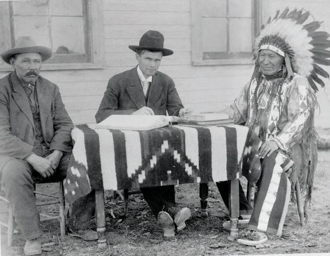 Chief American Horse taking American citizenship from the federal allotting surveyor and his interpreter Billy Garnett, circa 1907