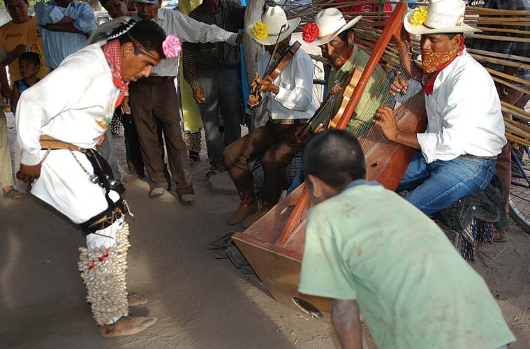 Yoreme pajko’ora dancing to the accompaniment of a harpist and fiddler