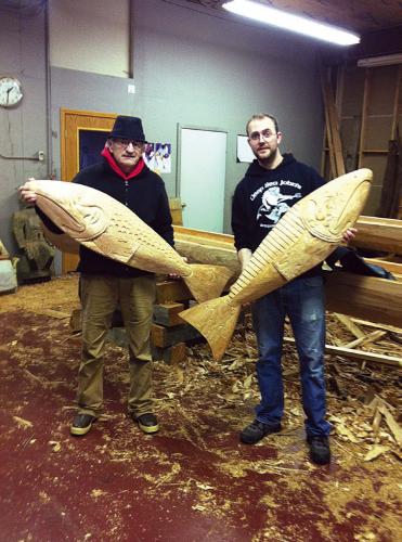 Bartow and assistance Jon Paden with two salmon carvings