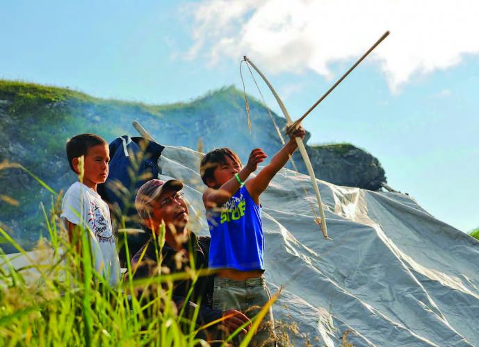 Jackie Matson with child shooting bow