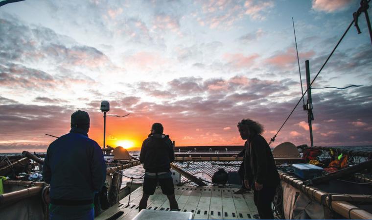crew members on boat at sunset