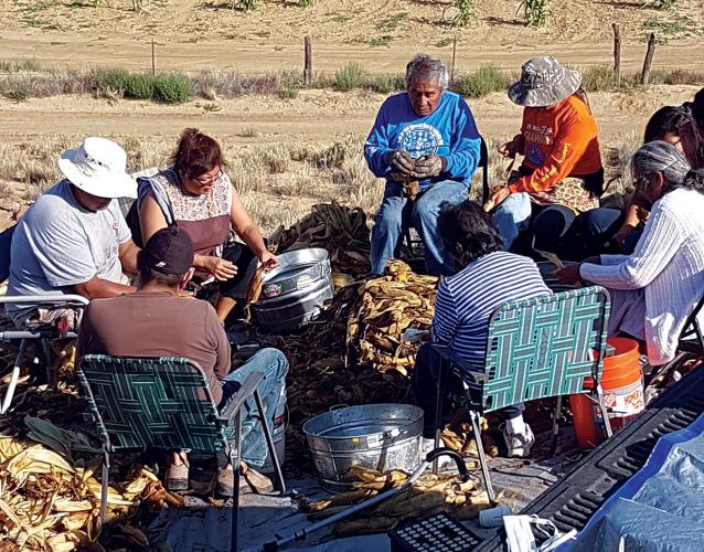 Community members shucking corn