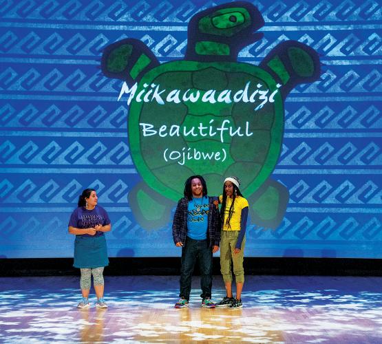 Actors standing in front of projected graphic