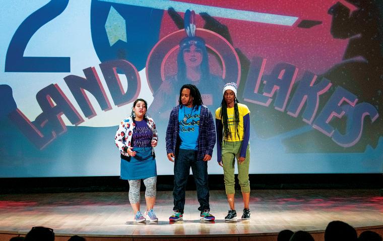 Three actors standing in front of projected graphic