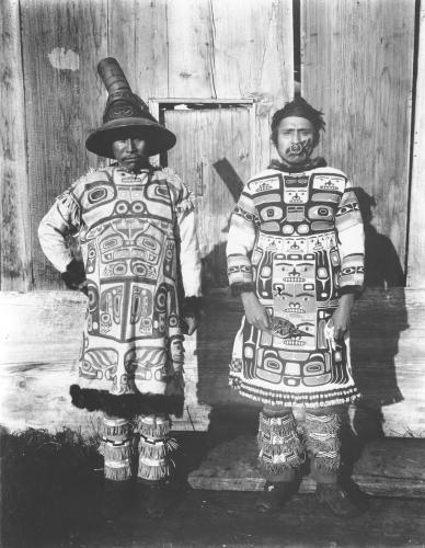 A photograph of Chilkat chiefs Coudahwoht (left) and Yehlh-gouhu (right) of the Con-nuh-ta-di at Klukwan wearing traditional Tlingit tunics.