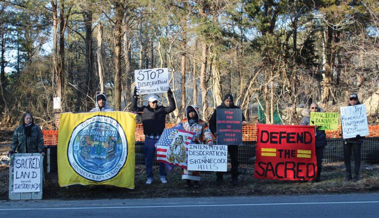 Members of the Shinnecock Indian Nation hold signs protesting construction on sacred burial sites.