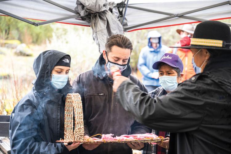 Sheila Santamaria and Elijah Knight receive a cradleboard from Theresa Williams-Lundy. Keith Turner gives them a blessing