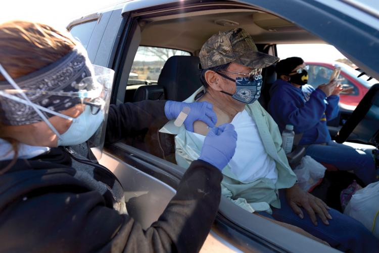 Vicky Charley gives Edison Sloan his first dose of the Pfizer-BioNTech vaccine in his car