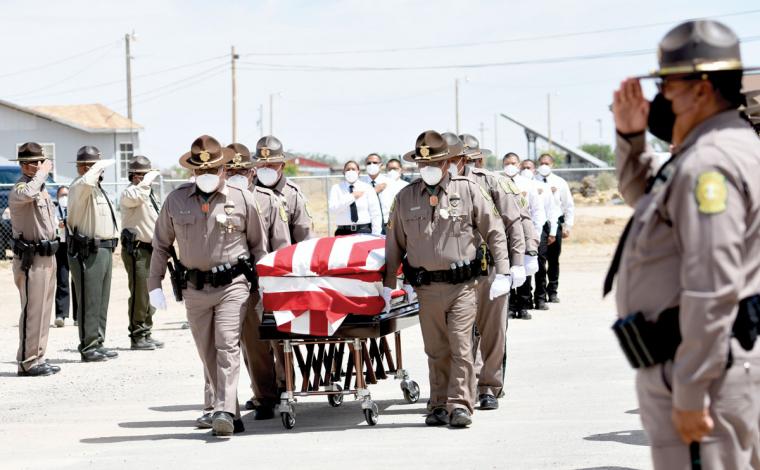 Fellow officers salute fallen Navajo Nation Police Officer Michael Lee, whose casket is escorted by the Navajo Nation Police Honor Guard