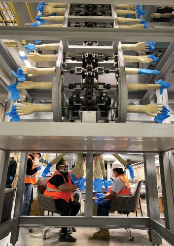 Rhino Health employee Nizhoni Long and her coworkers producing medical-grade nitrile gloves