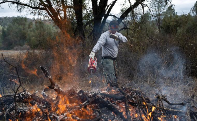 Elijah Knight protects himself from the radiant heat coming off a fire