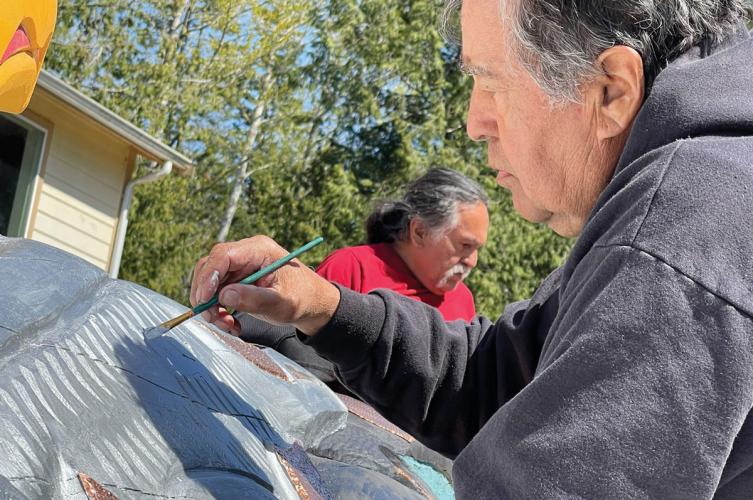 Lummi brothers Douglas and Jewell James painting the totem pole they carved
