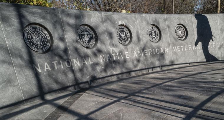 A granite wall featuring the emblems of the branches of the U.S. military: the Army, Marine Corps, Navy, Air Force and Coast Guard. 
