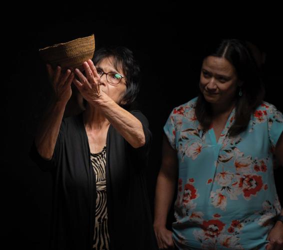 Mona Craven and Ramona Rosiere examine a basket hat
