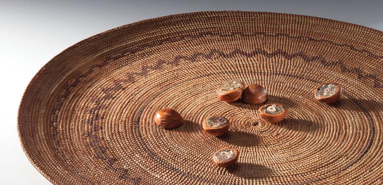 A woven tray with walnuts, used in a game called 'huuchuish'