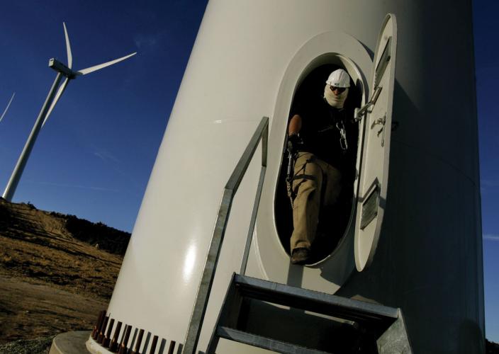 A person stepping out of the base of a wind turbine
