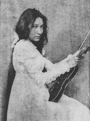 Zitkala-Ša, a Yankton Sioux woman, wearing a European-style dress and holding her violin