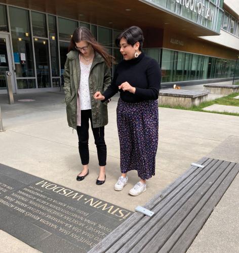 Sabrina Moshenko translates for for Jessica Wyliea sign written in Plains Cree language on the grounds of the University of British Columbia campus in Vancouver.