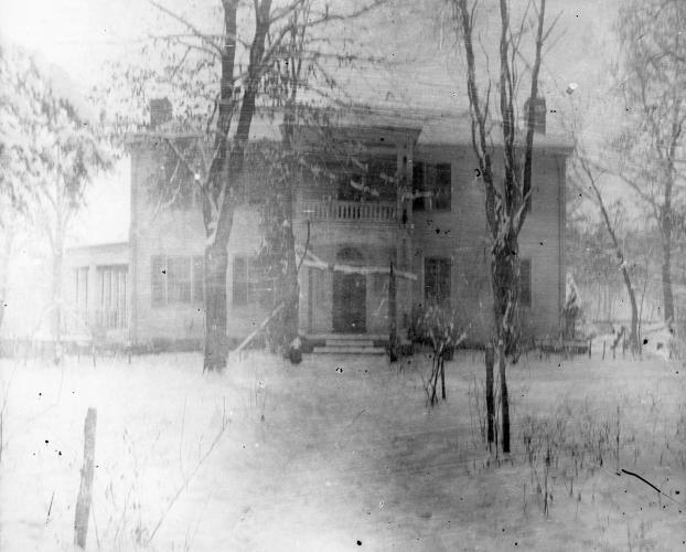 A faded black and white image of the Hunter's Home façade in winter. The ground is covered in snow.