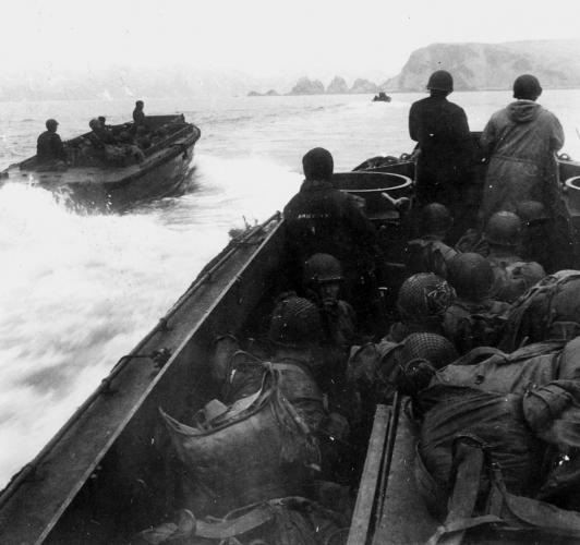 Three World War II U.S. Navy boats approach Attu Island. The photograph is in black and white and taken from the perspective of the furthest boat.