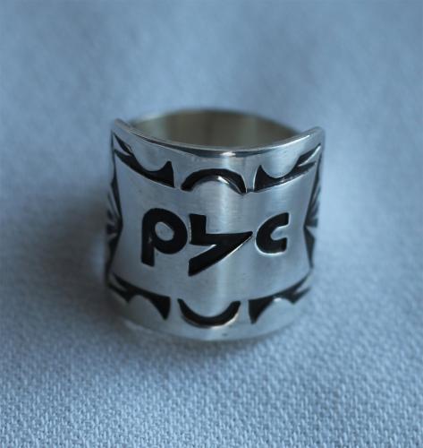 A silver ring carved with words in the Plains Cree language.