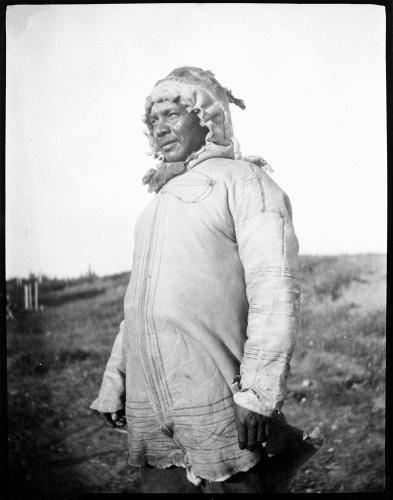 A black and white portrait of a man wearing a parka made of caribou hide and looking off to the left