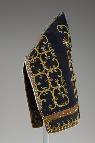 A black peaked cap with an intricate swirled beaded pattern