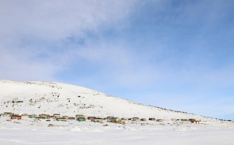 Houses of an Inuit community dot the snowy landscape.