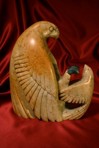 A soapstone sculpture of a songbird defending itself against a hawk